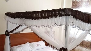 A bed with a canopy, white bedding, and a patterned floor. - Good Morning Hotel Rongo (Rongo)