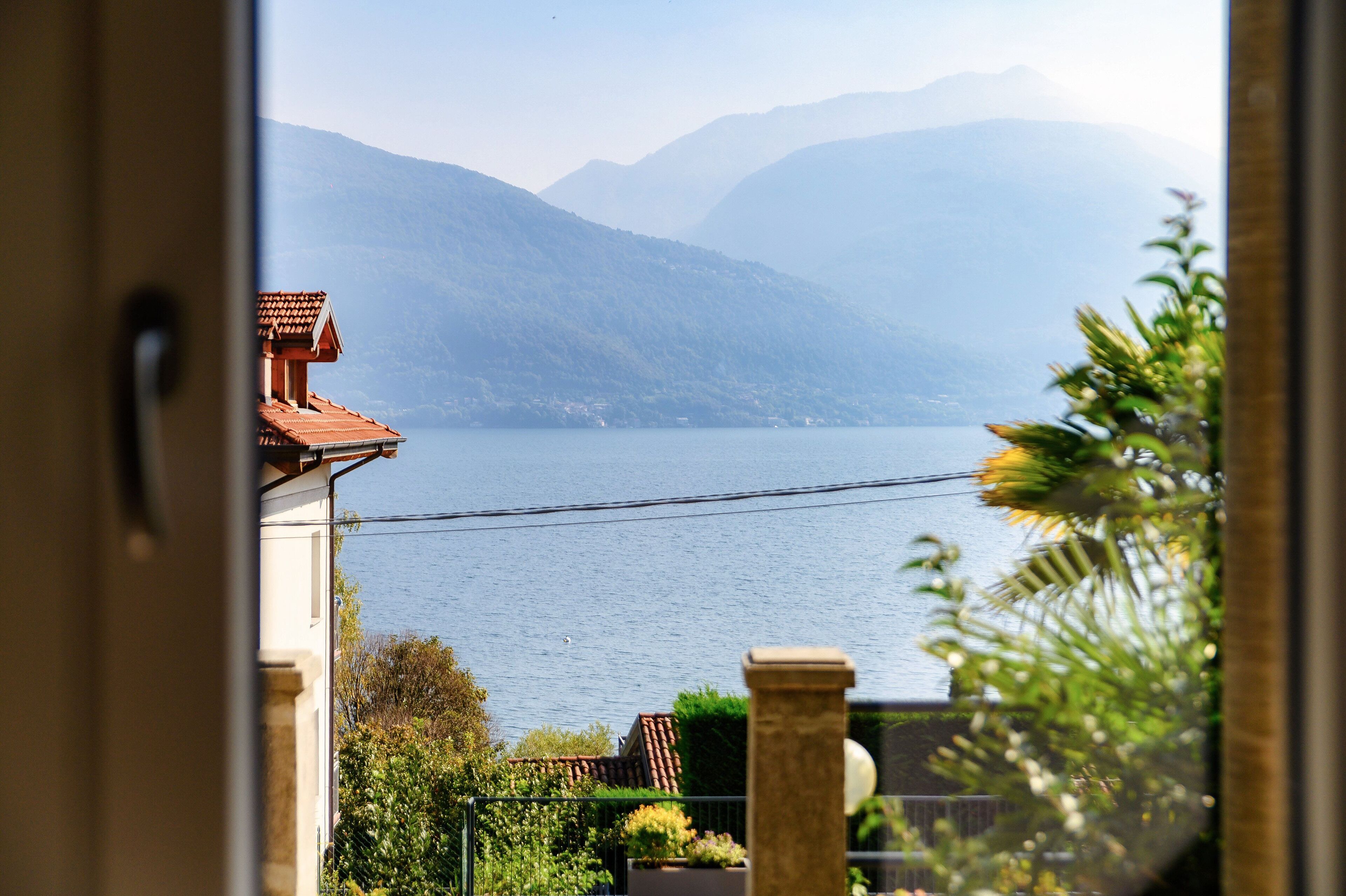 A view of a lake with mountains in the background, seen through a window with a door frame.