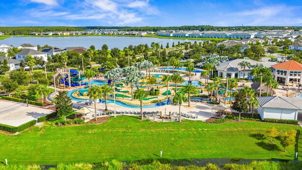 Un complexe hôtelier doté d’une piscine centrale entourée de palmiers et d’un parc aquatique.