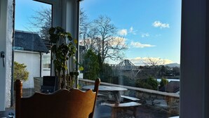 A room with a large window overlooking a patio area with outdoor seating.
