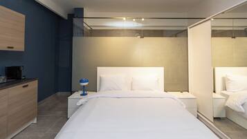 Un dormitorio moderno con una cama grande, mesitas de noche, un velador, un espejo y un armario.