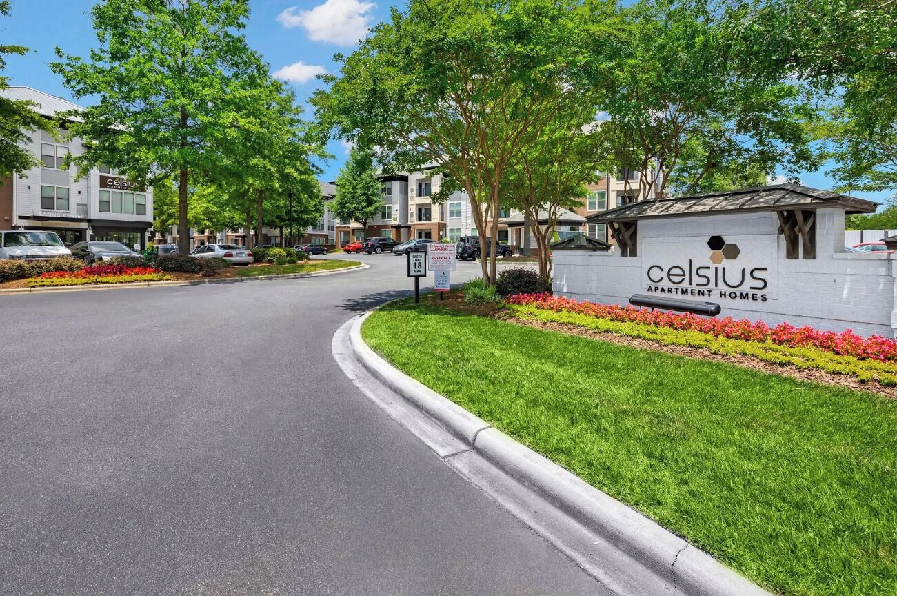 Un quartiere residenziale con edifici condominiali, una strada e un cartello per Celsius Apartment Homes.
