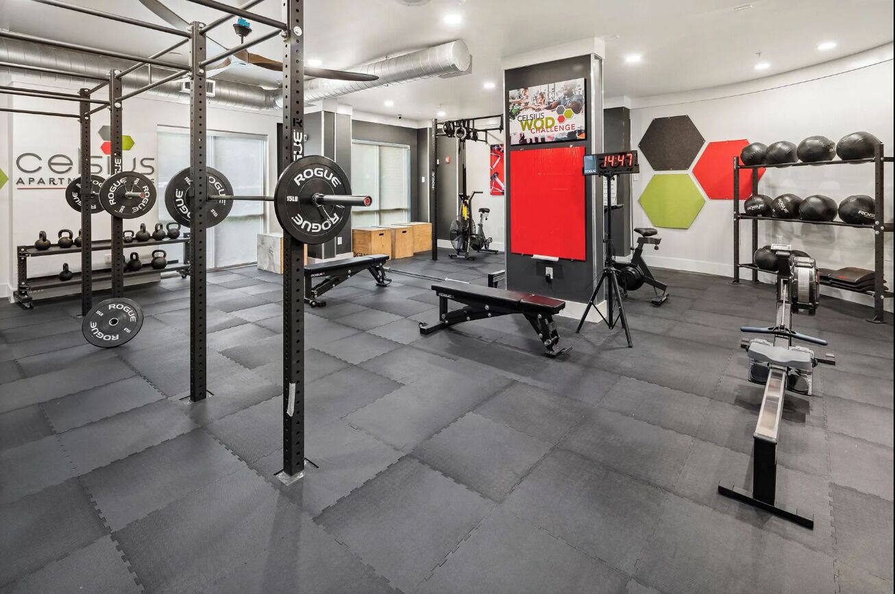 Una palestra con attrezzature per l'allenamento con i pesi, una panca e palle da ginnastica.