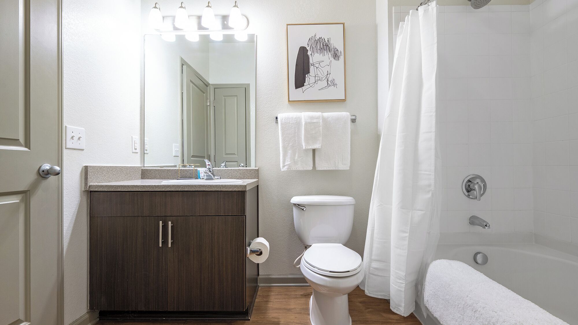 A bathroom with a toilet, sink, and bathtub.