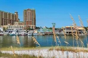 A marina with boats, a tall hotel, and a small tower structure.