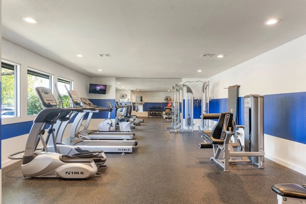 A gym with treadmills, ellipticals, and weight machines. - Landing Tulsa near Woodland (Tulsa)