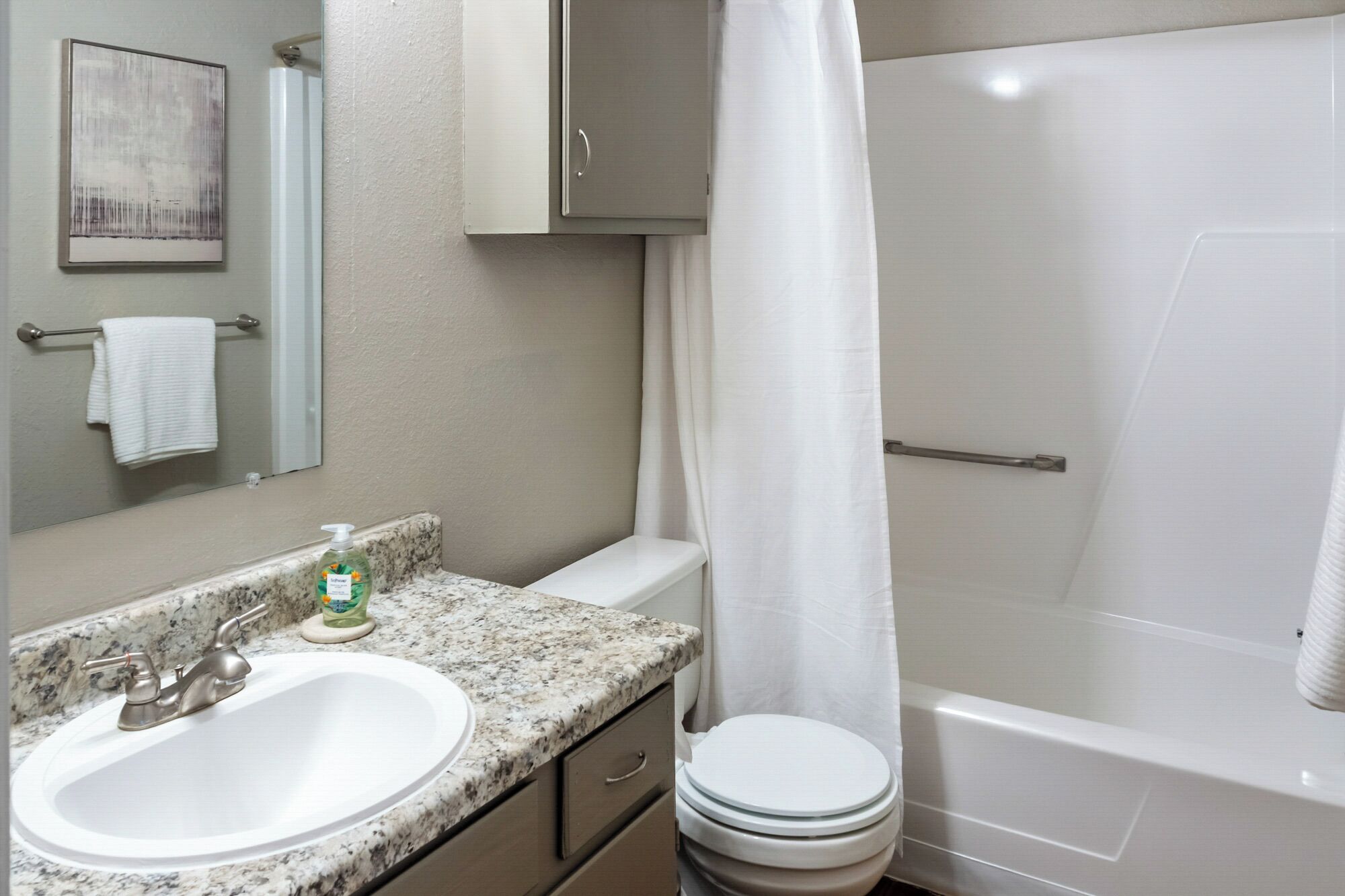 A bathroom with a sink, toilet, and shower.