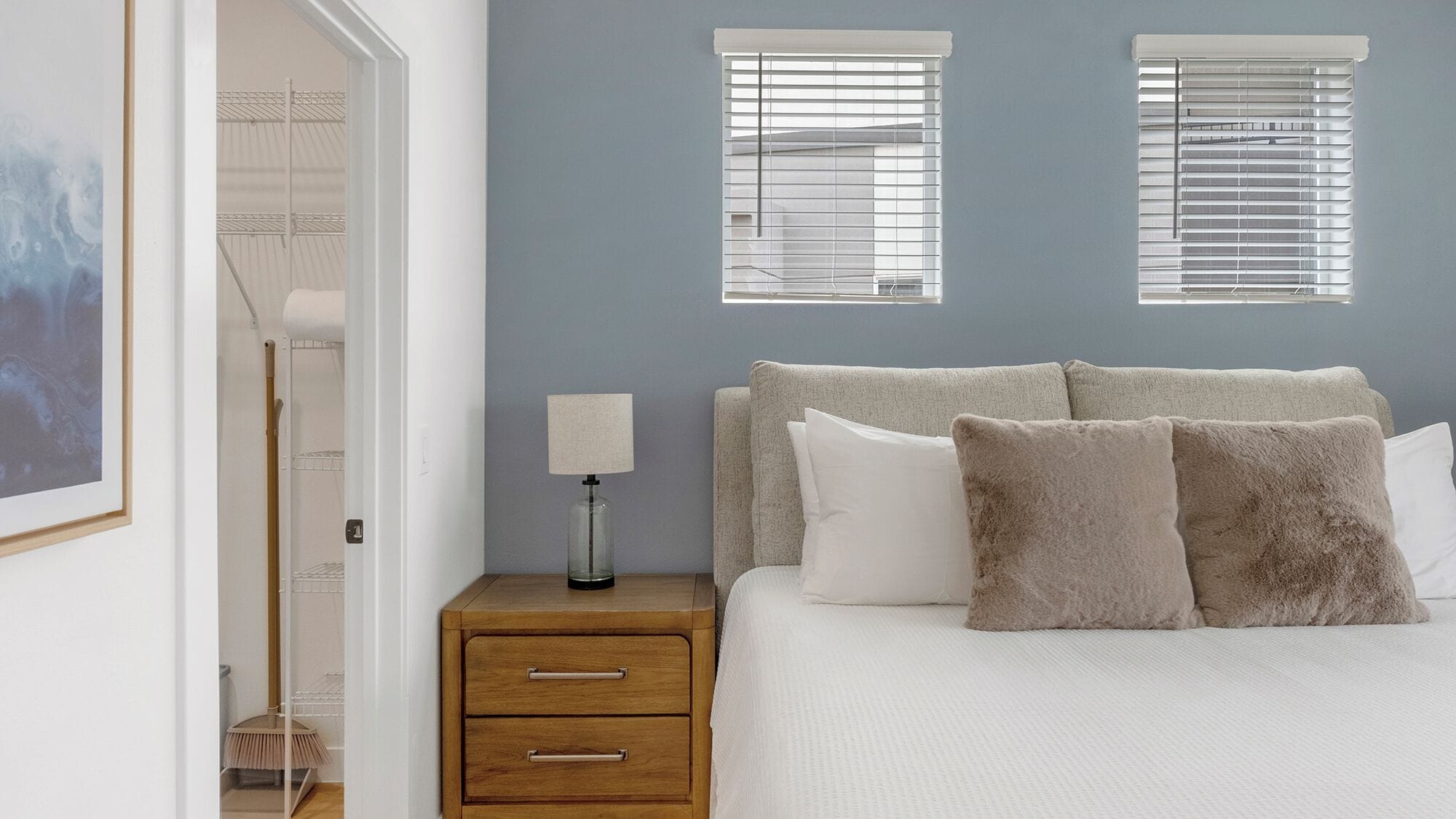 Une chambre à coucher comprenant un lit, deux tables de chevet, une commode et une lampe fixée au mur.
