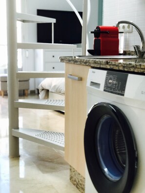 A modern laundry area with a washing machine, a dryer, and a countertop with a coffee machine.