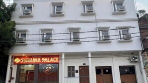 Egy épület, amelyen a „SUNAINA PALACE” feliratú tábla látható, és számos ablaka van.
