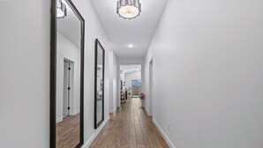 A hallway with wooden flooring, white walls, and large mirrors. - Desert Chic Glendale Oasis,  Near Stadium,  BBQ (Glendale)