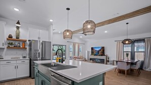 A modern kitchen with a large island, stainless steel appliances, and pendant lighting. - Desert Chic Glendale Oasis,  Near Stadium,  BBQ (Glendale)