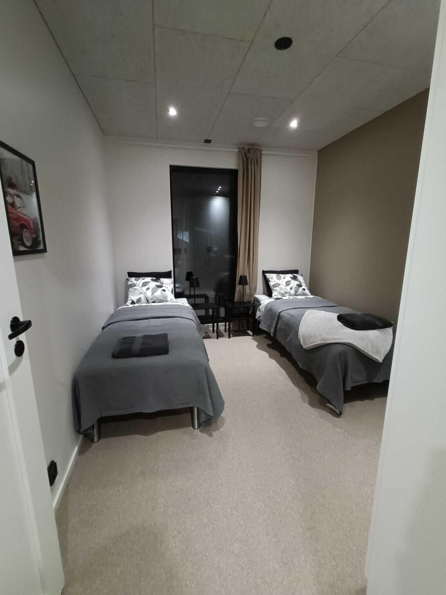 Un dormitorio con dos camas individuales, un escritorio y una silla.