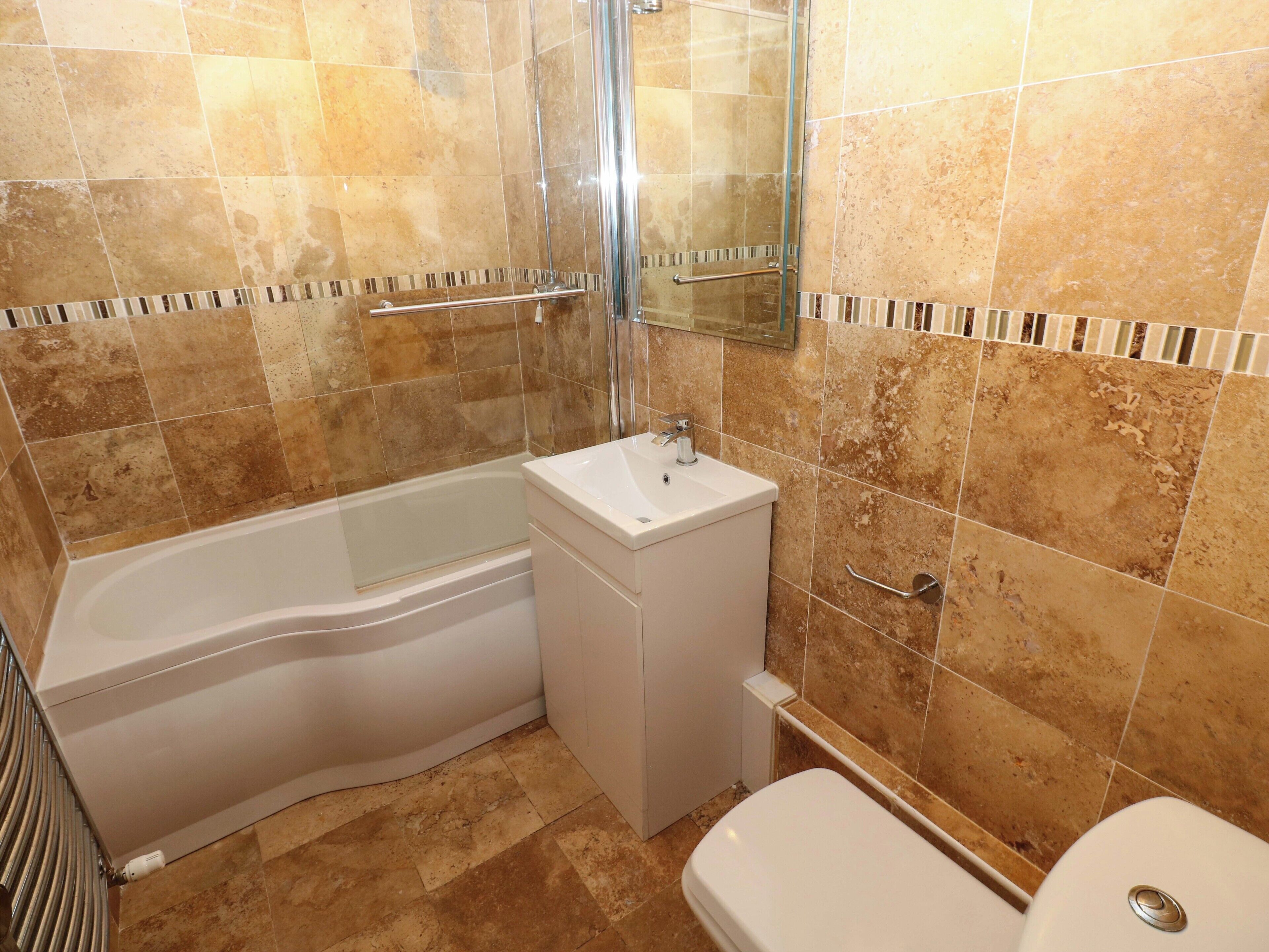 Un baño con bañera, lavabo e inodoro.