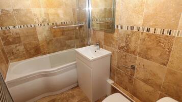 Un baño con bañera, lavabo e inodoro.