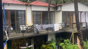 A two-story building with a red roof, surrounded by palm trees. - Palolem Sea n' Sand Beach View   (Canacona)
