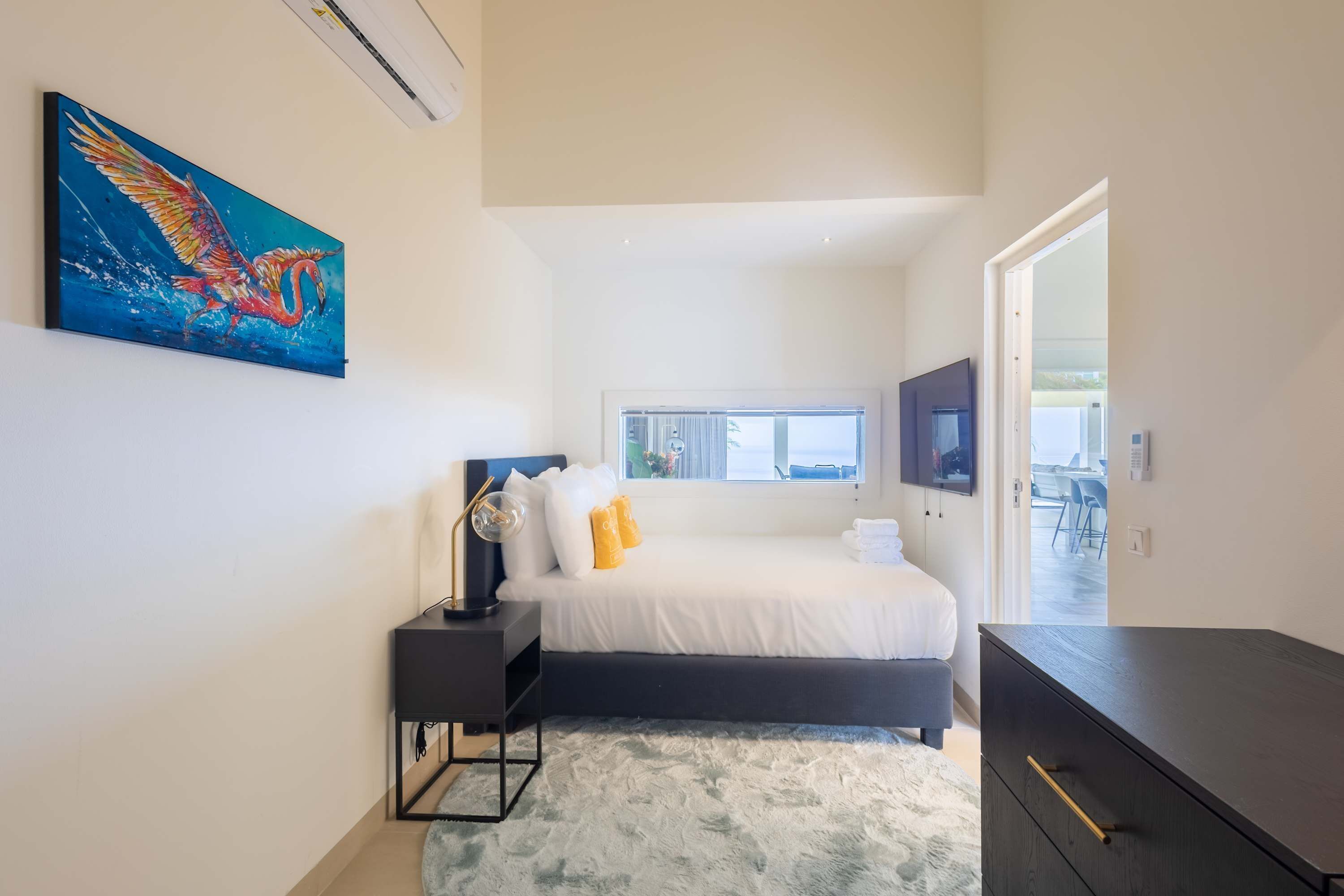 A modern bedroom with a bed, bedside table, and a painting.