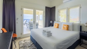 Ein Hotelzimmer mit Bett, Schreibtisch, Stuhl und Blick ins Freie.
