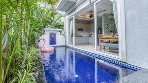 A swimming pool with a pink flamingo float, surrounded by lush greenery. - Luxury 4bhk Pool Getaway in North Goa Villa Kaia (Valpoy)