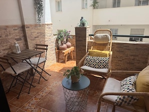 A patio area with a table, chairs, and potted plants. - La Casa Bonita (Benalmádena)