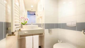 Un baño pequeño con lavamanos, espejo e inodoro.