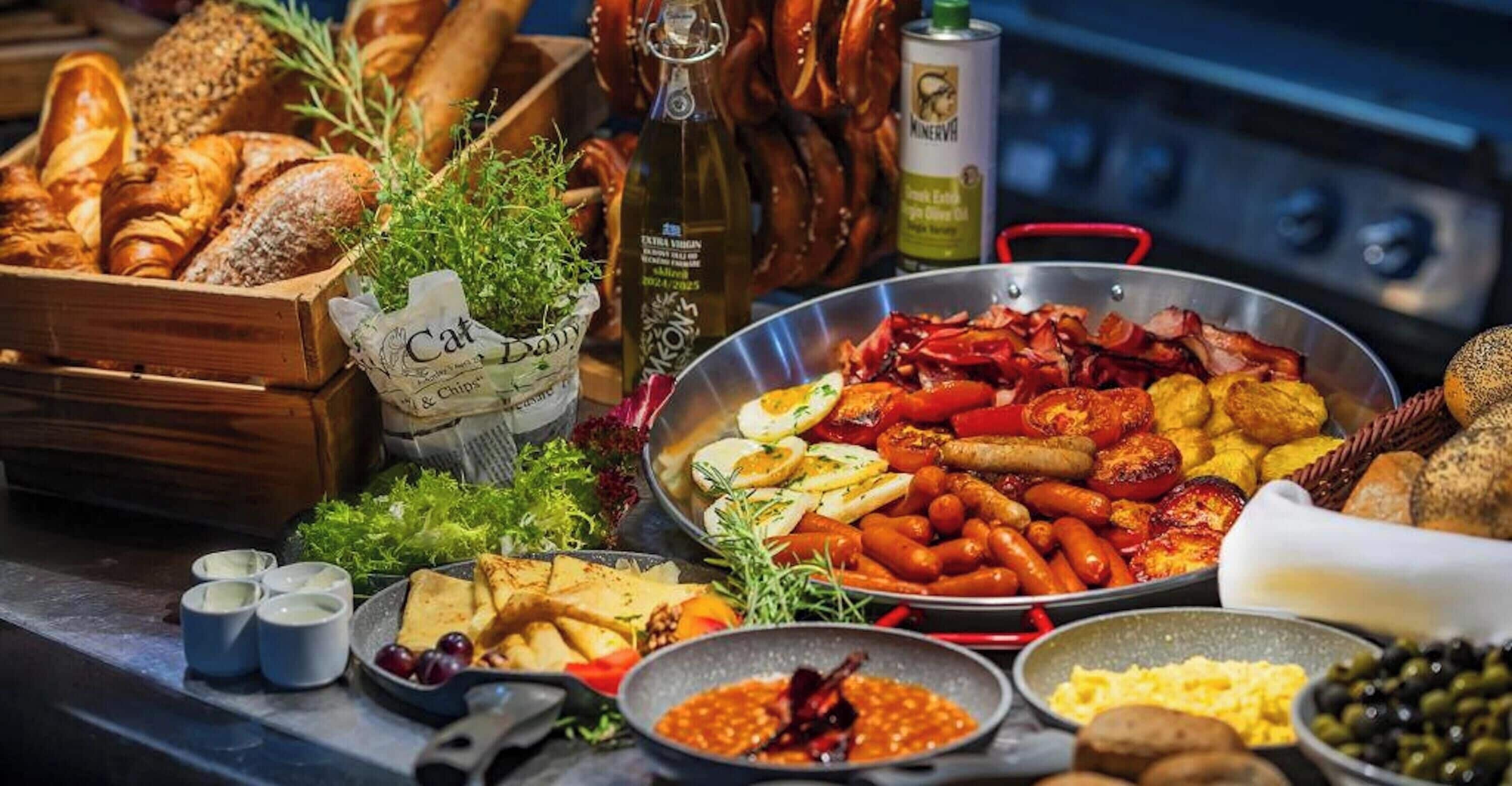 A variety of food items including bread, sausages, and vegetables on a counter.