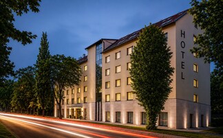 A multi-story hotel with a modern architectural design, featuring a prominent entrance and a well-lit facade.