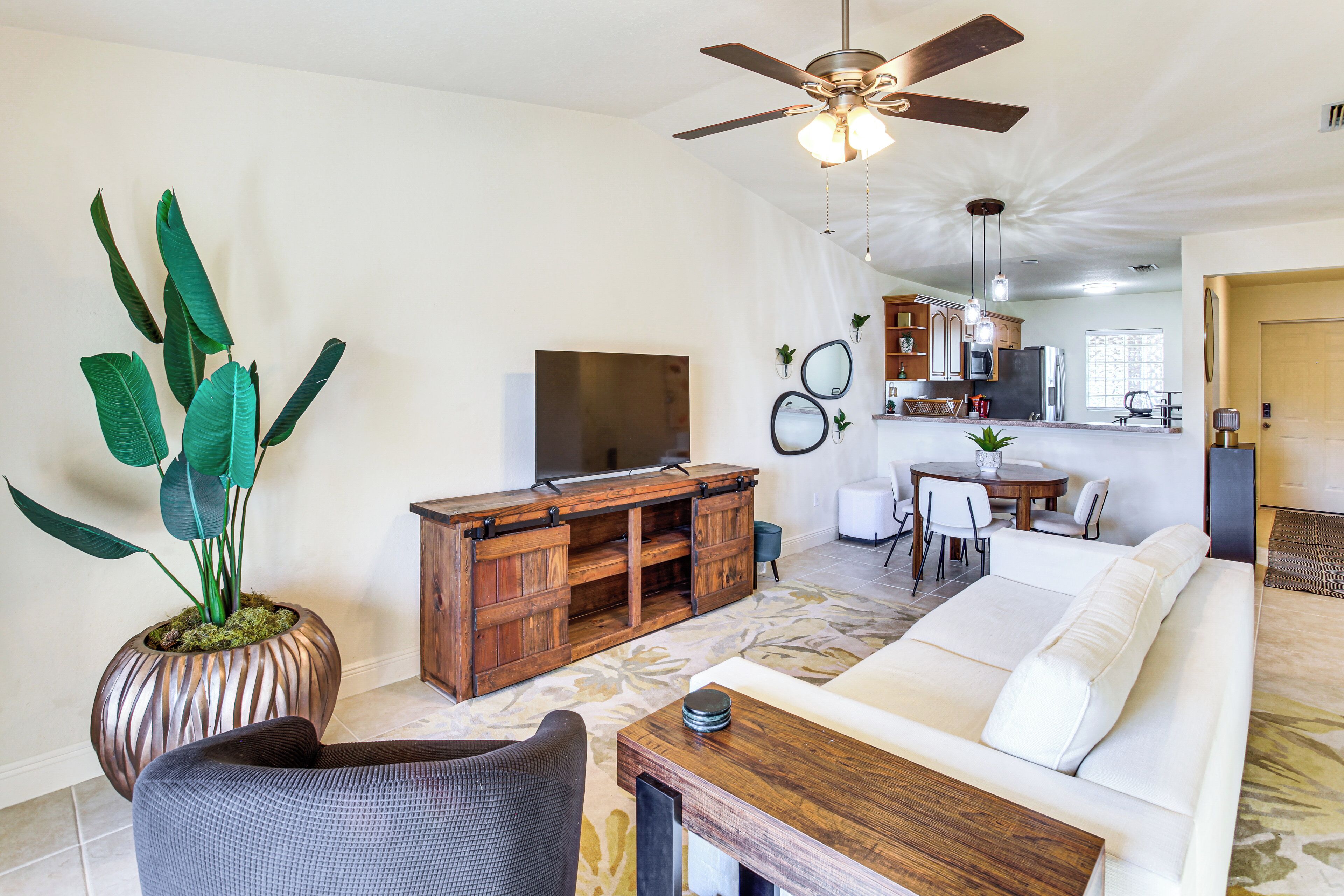 A living room with a sofa, a coffee table, a TV, and a ceiling fan.