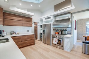 A modern kitchen with wooden cabinets, stainless steel appliances, and a white countertop. - 1 Mi to Dtwn & Mill Avenue! Home w/ Outdoor Oasis (Tempe)