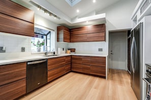A modern kitchen with wooden cabinets, a dishwasher, and a stainless steel refrigerator. - 1 Mi to Dtwn & Mill Avenue! Home w/ Outdoor Oasis (Tempe)