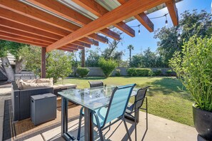 An outdoor patio with a glass-top table, blue chairs, and a wooden pergola. - 1 Mi to Dtwn & Mill Avenue! Home w/ Outdoor Oasis (Tempe)