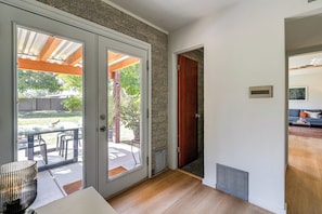 A room with a sliding glass door leading to an outdoor patio, a wooden door, and a radiator on the floor.