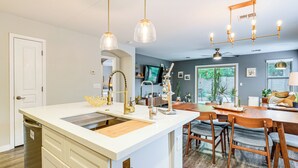 A modern kitchen with a central island, wooden chairs, and pendant lighting. - Pool Access! Suburban Home 11 Mi to Dtwn Gilbert (Gilbert)