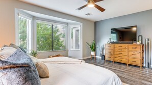 A bedroom with a bed, a ceiling fan, a TV, a wooden dresser, and a window with blinds. - Pool Access! Suburban Home 11 Mi to Dtwn Gilbert (Gilbert)