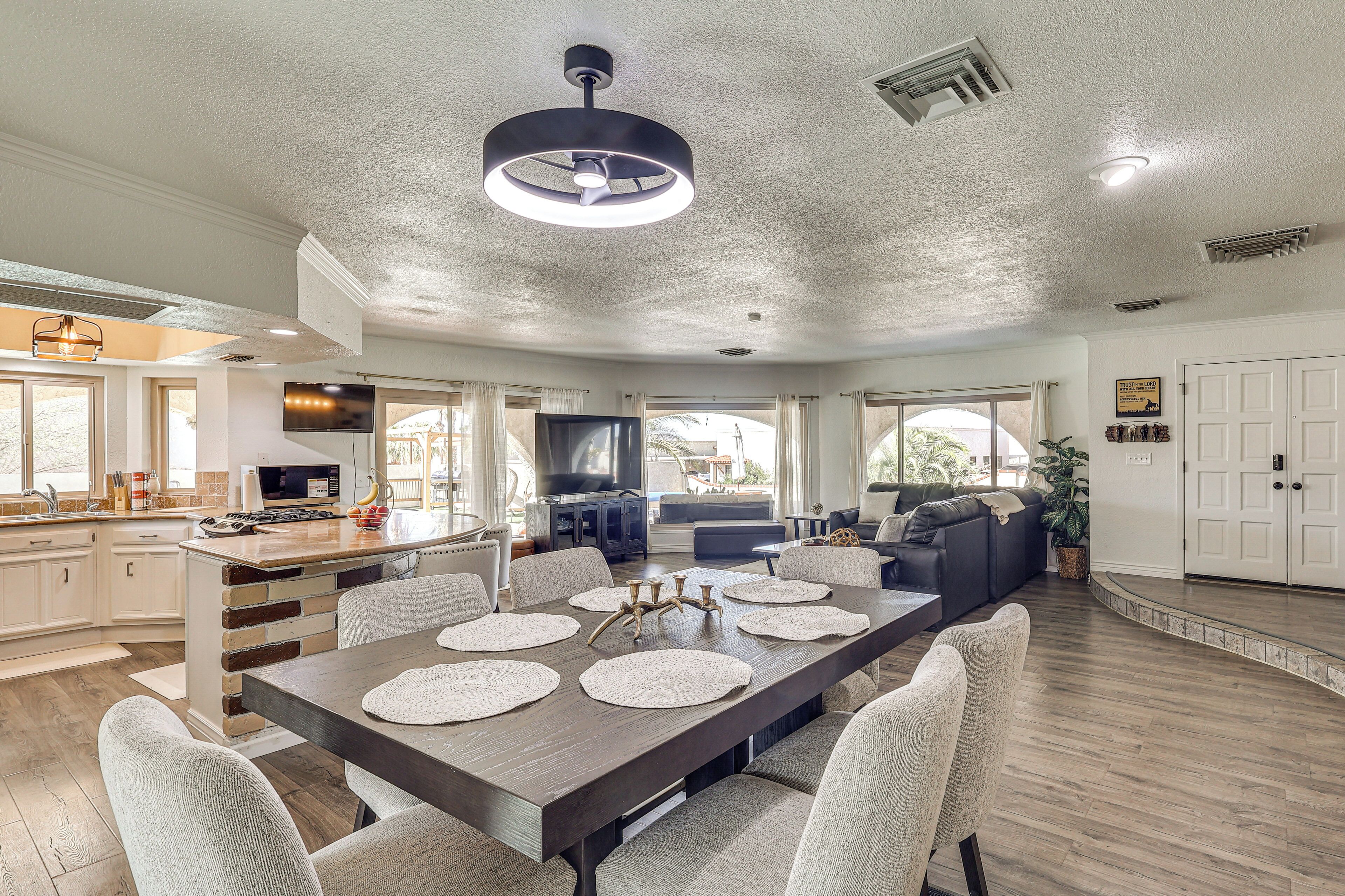 A spacious living area with a dining table, seating, and a kitchen in the background.