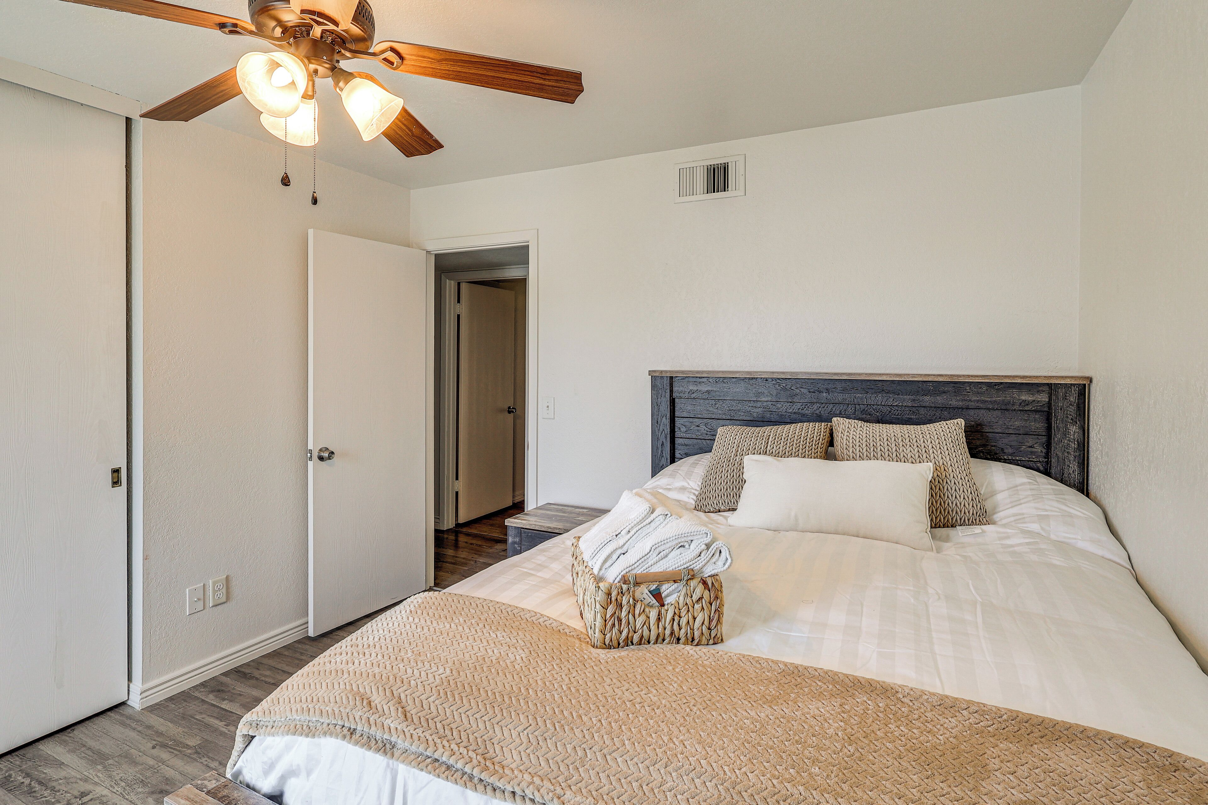 Un dormitorio con cama, ventilador de techo y puerta.