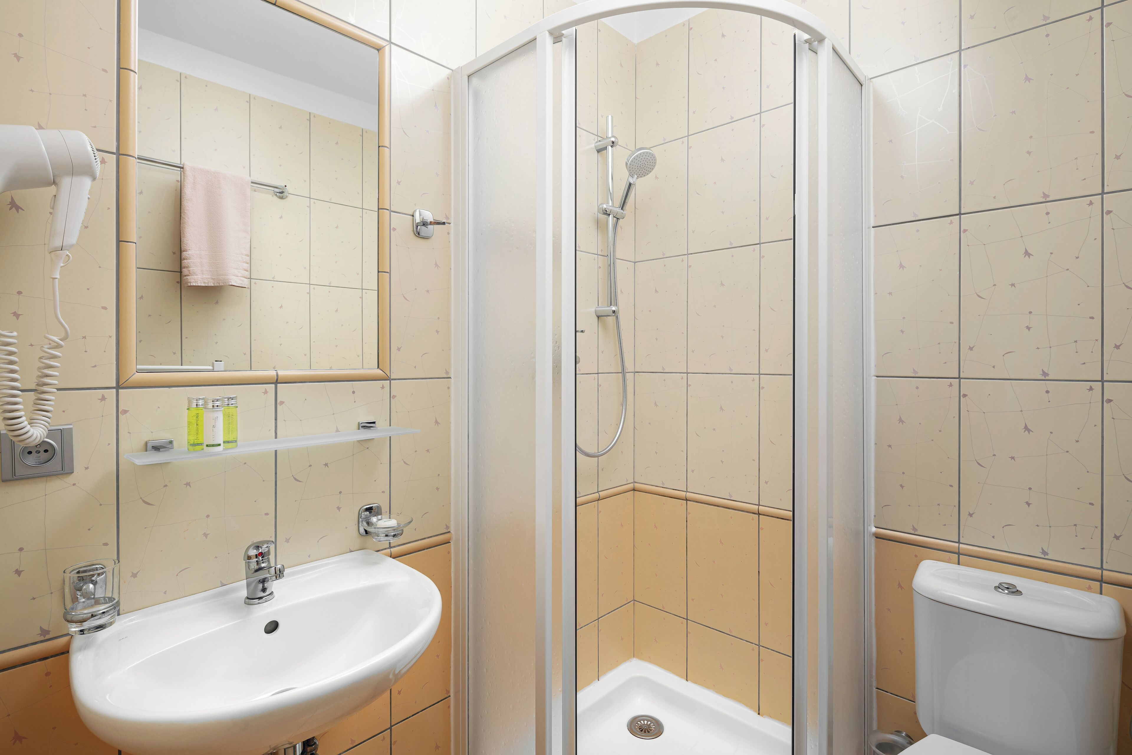 A bathroom with a sink, toilet, and shower.