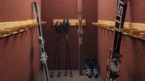 A ski storage room with wooden racks holding skis and ski poles. - Pension U Komárků (Špindlerův Mlýn)