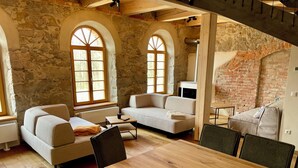 Una sala rústica con paredes de piedra, vigas de madera y una gran mesa de madera.