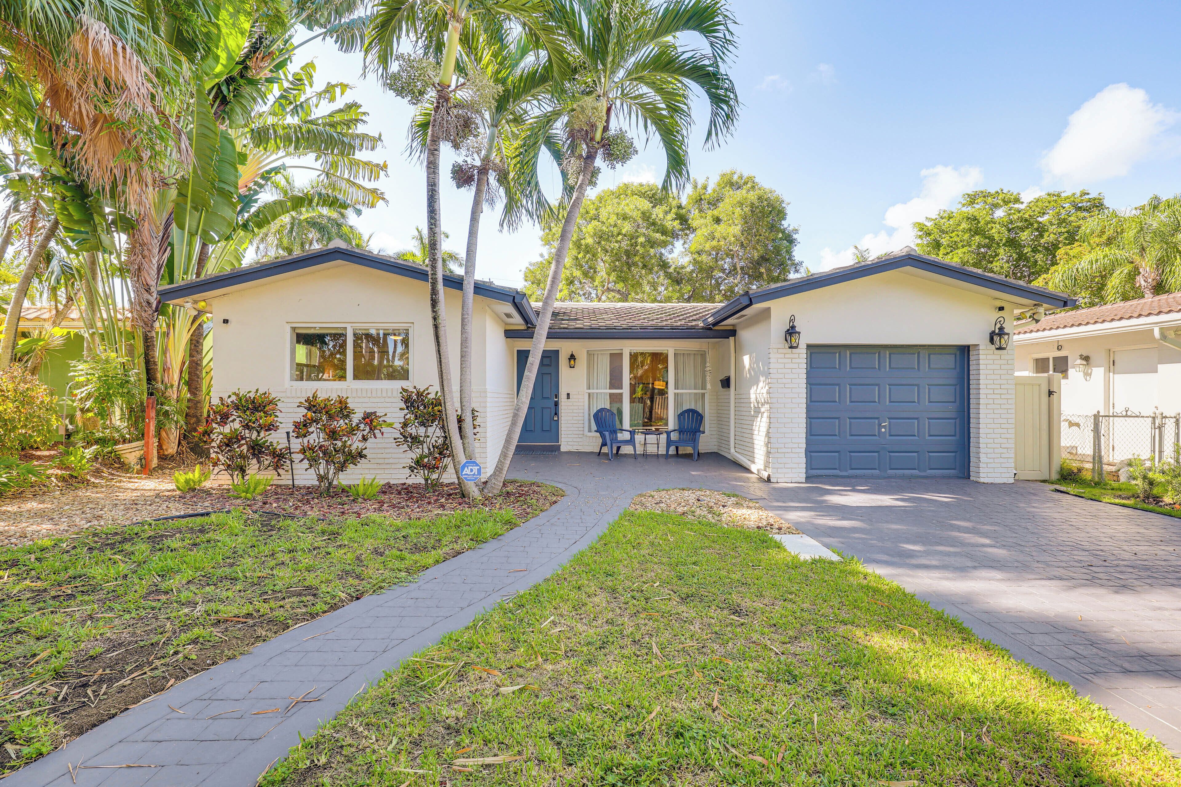 A two-story house with a front porch, a garage, and a well-maintained lawn.