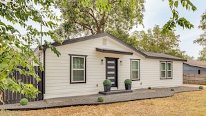 A single-story house with a front door, two windows on the first floor, and a small front yard with a gravel path and two potted plants. - Near Historic Georgetown Square! Updated Home (Georgetown)