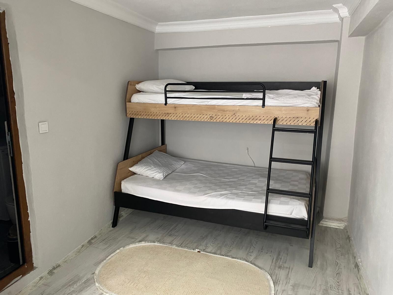 Un letto a castello con una testiera in legno e un letto inferiore con materasso e cuscini.