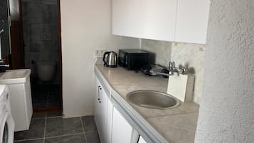 Eenvoudig appartement | Privékeuken | Een koelkast, kookgerei, borden en bestek