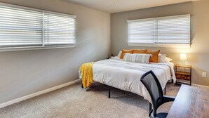 A bedroom with a bed, a desk, a chair, a ceiling fan, and two windows with blinds. - 3 Mi to Texas Tech: Cozy Home w/ Private Yard! (Lubbock)