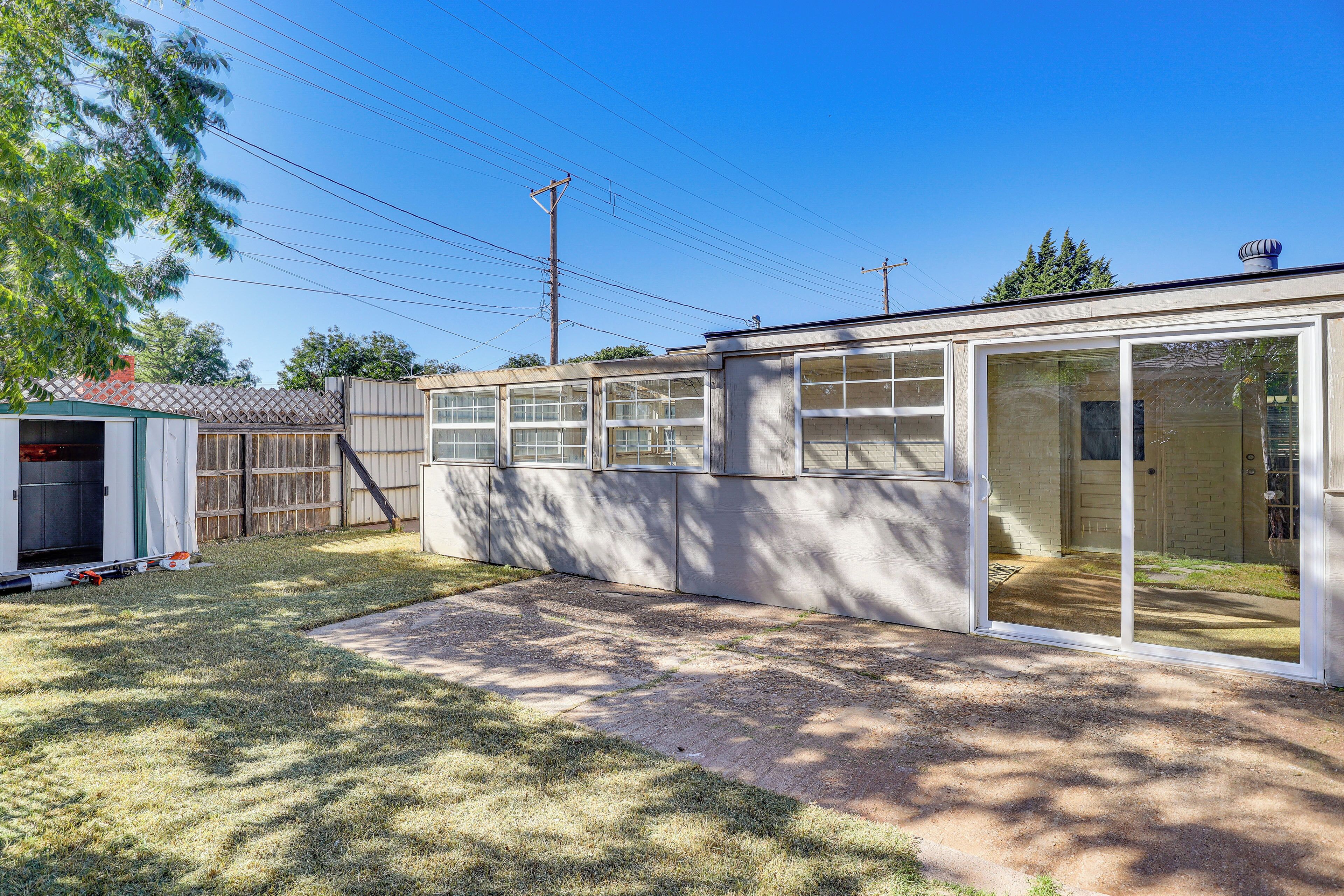 Einbungalow mit Garage, überdachter Terrasse und einem eingezäunten Garten.