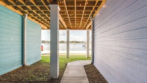 A covered outdoor area with a concrete pathway leading to a body of water. - Fish, Swim & Explore: Panama City Gem w/ Boat Slip (Panama City)
