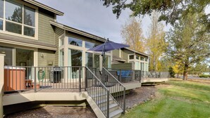 A two-story house with a covered patio, outdoor seating, and a staircase leading to the upper level.