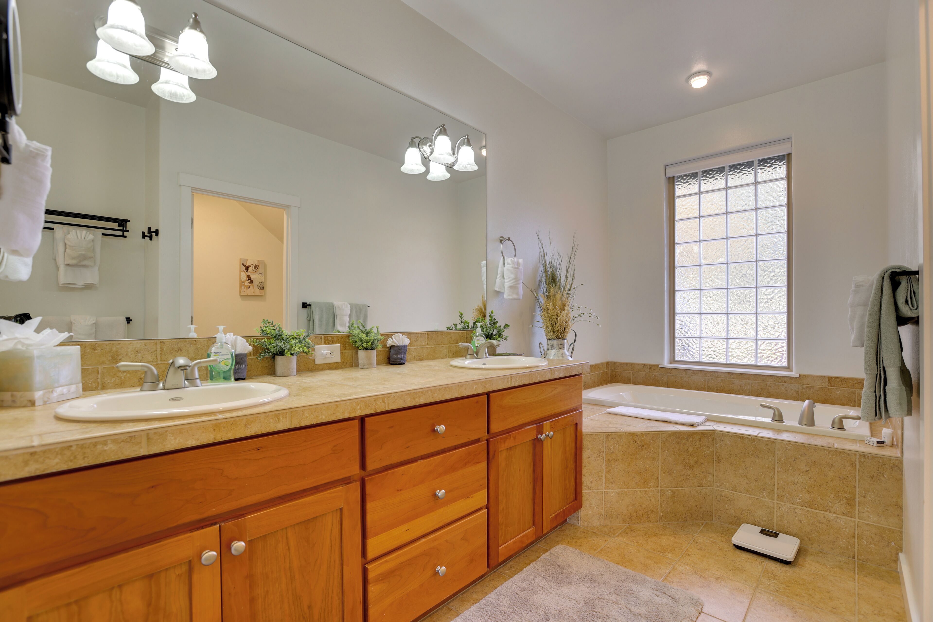 Un baño moderno con dos lavamanos, un espejo grande y una bañera.