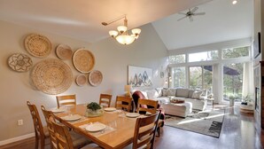 A spacious dining area with a wooden table and chairs, surrounded by decorative woven plates on the walls.