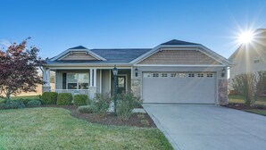A two-story house with a front porch, a garage, and a well-maintained lawn.